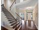 Elegant foyer showcasing a staircase with wood steps, iron railings, and gleaming hardwood floors throughout at 901 Deercross Ln, Waxhaw, NC 28173