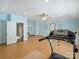 Bright home gym with light blue walls, a ceiling fan, wood flooring, and workout equipment at 901 Deercross Ln, Waxhaw, NC 28173
