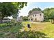 A spacious backyard featuring a two-story home, a patio, mature trees, and lush green grass at 9029 Torrence Crossing Dr, Huntersville, NC 28078