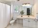 Bright bathroom with white vanity, shower with curtain and neutral tile floors at 9029 Torrence Crossing Dr, Huntersville, NC 28078
