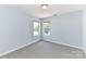 Simple bedroom with neutral carpet, two windows, and light blue walls at 9029 Torrence Crossing Dr, Huntersville, NC 28078