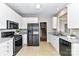 Kitchen featuring white cabinets, modern black appliances, and gray countertops at 9029 Torrence Crossing Dr, Huntersville, NC 28078
