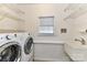 Bright laundry room with sink, shelving, washer and dryer at 9029 Torrence Crossing Dr, Huntersville, NC 28078