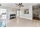 Spacious living room with fireplace, tile floors, ceiling fan, and opening to kitchen at 9029 Torrence Crossing Dr, Huntersville, NC 28078