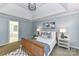 Comfortable bedroom featuring tray ceilings and a view into the main bathroom at 9029 Torrence Crossing Dr, Huntersville, NC 28078