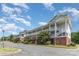 Two-story condo building with brick facade, street view, and multiple covered outdoor porches at 9271 Meadow Vista Rd, Charlotte, NC 28213