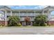 Well-maintained condo building featuring two stories with white railings and mature landscaping at 9271 Meadow Vista Rd, Charlotte, NC 28213