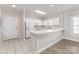 Bright kitchen with white cabinets, countertops, and appliances plus tile flooring at 9271 Meadow Vista Rd, Charlotte, NC 28213