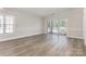 Spacious living room with hardwood floors, large window, and glass doors to the balcony at 9271 Meadow Vista Rd, Charlotte, NC 28213
