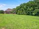 Expansive backyard featuring a lush green lawn and mature trees offering serene privacy at 1011 Duntov Dr, Monroe, NC 28110
