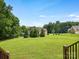 Expansive backyard featuring a lush green lawn and mature trees offering serene privacy at 1011 Duntov Dr, Monroe, NC 28110