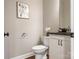 Powder room with a toilet, granite vanity, and decorative mirror at 1011 Duntov Dr, Monroe, NC 28110