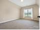 Bright, empty bedroom with a large window and neutral carpet, awaiting personal touches at 1011 Duntov Dr, Monroe, NC 28110