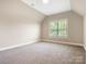 Bright, empty bedroom with a large window and neutral carpet, awaiting personal touches at 1011 Duntov Dr, Monroe, NC 28110