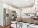 Bright kitchen featuring white cabinets, stainless steel appliances, and a dark granite countertop island with seating at 1011 Duntov Dr, Monroe, NC 28110