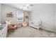 Bright Bedroom with a crib, rocking chair, and toys, creating a cozy and playful environment at 12415 Es Draper Dr, Huntersville, NC 28078