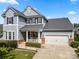 Charming two-story home featuring gray siding, black shutters, and a well-manicured front yard with inviting front porch at 12415 Es Draper Dr, Huntersville, NC 28078