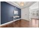 Inviting foyer with dark blue accent wall, hardwood floors, stylish console table, and a decorative mirror at 12415 Es Draper Dr, Huntersville, NC 28078