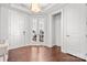 Bright foyer featuring white trim, hardwood floors, glass-paneled office doors, and a view of the home gym at 12415 Es Draper Dr, Huntersville, NC 28078