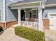Cozy front porch with white railing, brick accents, and hanging flower baskets that create a welcoming entrance at 12415 Es Draper Dr, Huntersville, NC 28078