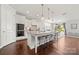 Open-concept kitchen featuring a large island with seating, modern pendant lighting, and stainless steel appliances at 12415 Es Draper Dr, Huntersville, NC 28078