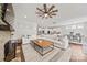 Open-concept living room with a stone fireplace flows into a modern kitchen and dining area at 12415 Es Draper Dr, Huntersville, NC 28078