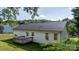 Back of home featuring a small wood deck, white vinyl siding, and windows with tree-lined backdrop at 1265 39Th Street Cir, Hickory, NC 28602