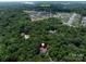 Aerial view of a home nestled in a forest, with Lake Wylie and neighborhood in the distance at 14019 Fountain Ln, Charlotte, NC 28278