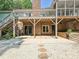 View of the home's covered back patio with brick accents and stone path to gravel area at 14019 Fountain Ln, Charlotte, NC 28278