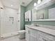 Renovated bathroom with white tile shower, modern vanity, and neutral green walls at 14019 Fountain Ln, Charlotte, NC 28278