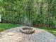 The backyard has a cozy firepit area surrounded by gravel and mature trees at 14019 Fountain Ln, Charlotte, NC 28278