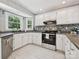 Bright kitchen with white cabinetry, stainless steel appliances, and a stylish backsplash at 14019 Fountain Ln, Charlotte, NC 28278