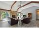 Inviting living room featuring vaulted ceilings with wooden beams, a stone fireplace, and a TV at 14019 Fountain Ln, Charlotte, NC 28278