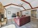 Bright living room features vaulted ceilings with beams, stone fireplace, and wood-look floors at 14019 Fountain Ln, Charlotte, NC 28278