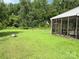 Large grassy backyard with an enclosed porch and lush green trees at 1412 Cold Creek Pl, Huntersville, NC 28078
