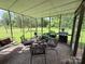 Enclosed porch with a brick floor, dining table, and BBQ grill for outdoor dining at 1412 Cold Creek Pl, Huntersville, NC 28078
