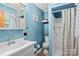 Well-lit blue bathroom features a shower stall, toilet and vanity at 143 Bostian Lake Rd, Statesville, NC 28677