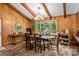 Cozy dining room with wooden beamed ceiling, a chandelier, wood paneling and natural light from large window at 143 Bostian Lake Rd, Statesville, NC 28677