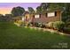 Charming brick home with a well-manicured lawn, front porch, and professionally landscaped front yard at 143 Bostian Lake Rd, Statesville, NC 28677