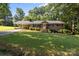 Lovely single-story brick home with a covered parking area, landscaped lawn, and mature trees at 143 Bostian Lake Rd, Statesville, NC 28677