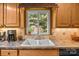 Charming kitchen featuring a farmhouse sink with a view to the lush, wooded outdoors at 143 Bostian Lake Rd, Statesville, NC 28677