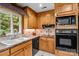 Functional kitchen featuring wooden cabinets, modern appliances, and a tile backsplash at 143 Bostian Lake Rd, Statesville, NC 28677