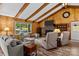 Inviting living room with wood paneled walls, vaulted ceiling, brick fireplace, and cozy furnishings at 143 Bostian Lake Rd, Statesville, NC 28677