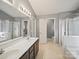 Primary bathroom featuring dual sinks, walk-in shower, enclosed tub, and separate toilet room at 14520 Cardamon Ct, Charlotte, NC 28273