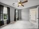 Neutral bedroom featuring carpet flooring, two windows, dark curtains and a ceiling fan at 14520 Cardamon Ct, Charlotte, NC 28273