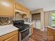 Kitchen featuring wood cabinets, modern backsplash, stainless steel appliances, and a convenient laundry area at 14520 Cardamon Ct, Charlotte, NC 28273