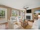 Cozy living room with a fireplace, ceiling fan, and plenty of natural light at 14520 Cardamon Ct, Charlotte, NC 28273