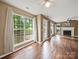 Bright living room with large windows, fireplace, ceiling fan, and beautiful wood floors at 14520 Cardamon Ct, Charlotte, NC 28273