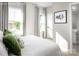 Bright bedroom features white bedding, two windows with curtains, and stylish wall art at 1474 Samuel St, Charlotte, NC 28206