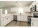 Modern kitchen featuring stainless steel appliances, white cabinets, and luxury vinyl plank flooring at 1628 Sandpiper Dr, Rock Hill, SC 29732